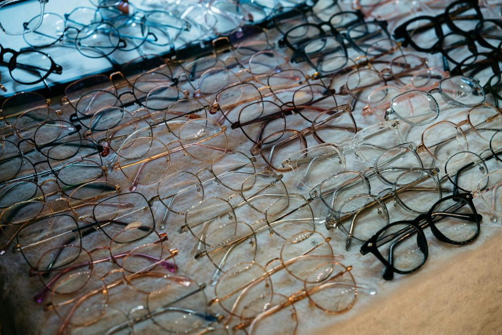A variety of eyeglasses with metal and plastic frames neatly arranged on a table.